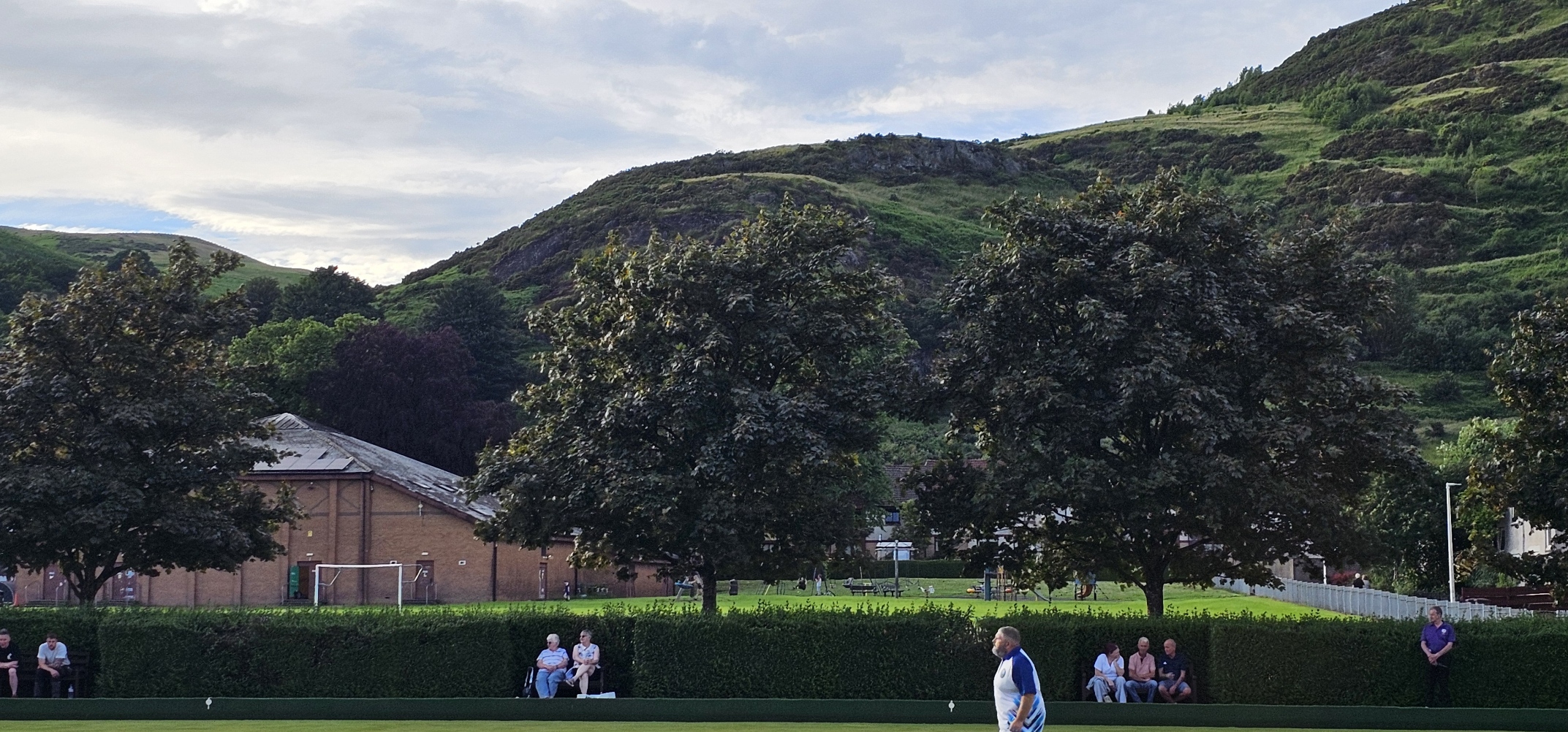 The stunning backdrop of the Ochil Hills overlooking the green, providing a beautiful and dramatic setting for the evening's matches
